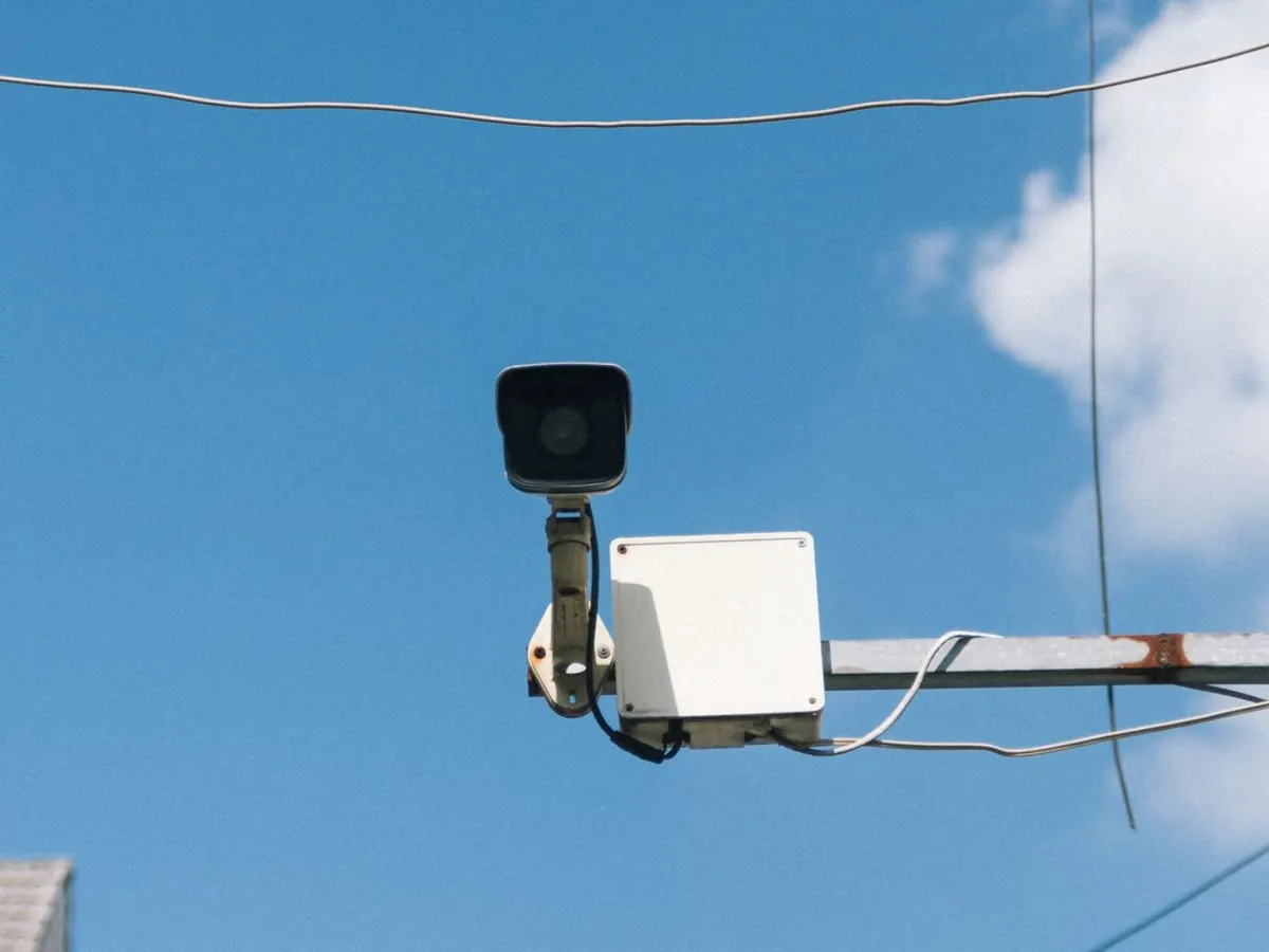 Câmera de segurança tipo bullet instalada em suporte externo com caixa de passagem