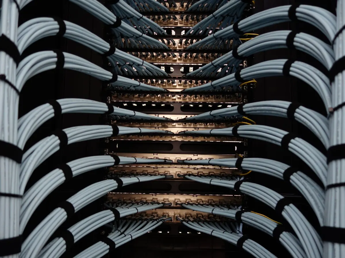 Rack de rede com cabos agrupados e organizados dos dois lados, chegando aos patch panels